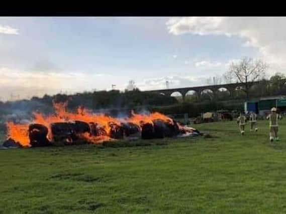 The hay bales being extinguished by Northants Fire and Rescue crews. There is an appeal for witnesses. Picture courtesy of Ollie Toseland.