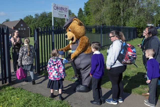 Wicky Bear sees the pupils into school.