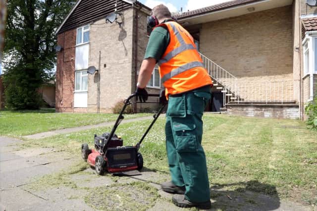 Grass cutting row: A council worker trims a public piece of grass on the Beanfield estate.