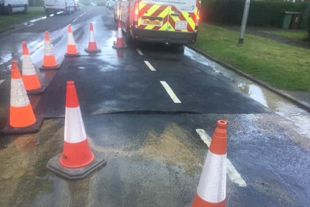 The new road surface can be seen bulging after water spurted up through it.