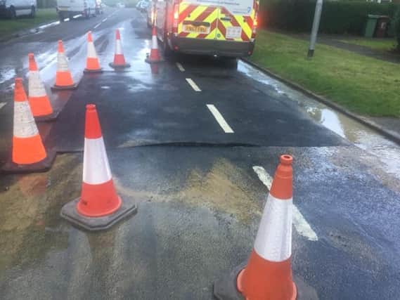 The new road surface can be seen bulging after water spurted up through it.