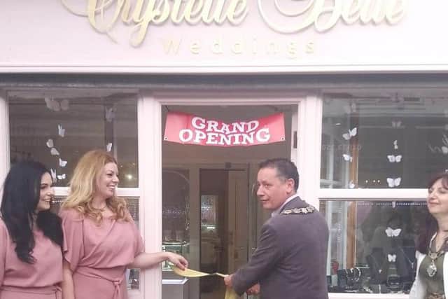 From left, sisters Crystal Hoyle and Chantelle Hewitt, with the mayor of Rushden Councillor Cesare Marinaro, cutting the ribbon during the grand opening of the Crystelle Belle shop in High Street, Rushden, on Saturday.