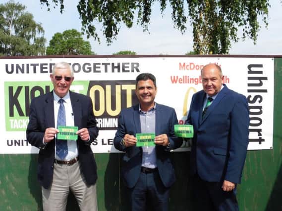 To launch the United Together campaign locally, Perry Akhtar (centre) provided a banner for Wellingborough Town alongside United Counties League director Jon Smith (right) and Doughboys president Laurie Owen