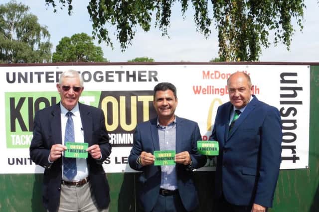 To launch the United Together campaign locally, Perry Akhtar (centre) provided a banner for Wellingborough Town alongside United Counties League director Jon Smith (right) and Doughboys president Laurie Owen