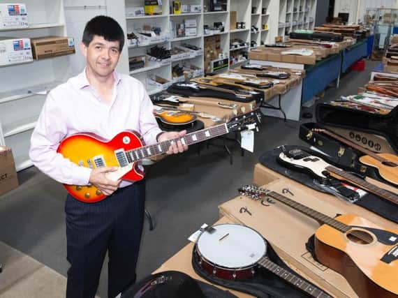 Auctioneer Paul Cooper and some of the thousands of pounds worth of guitars up for auction.