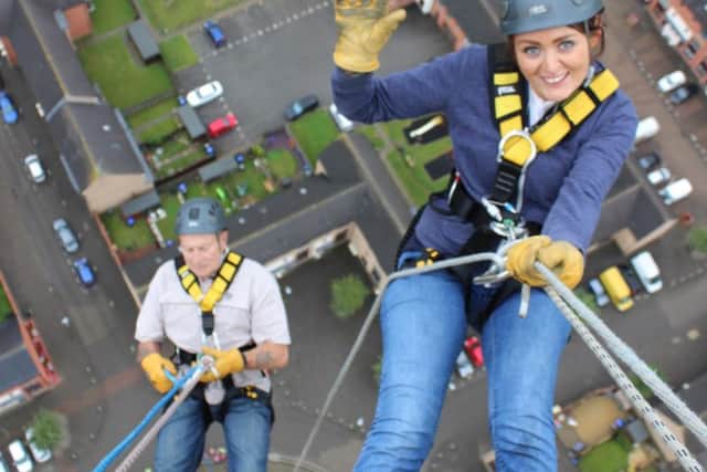 Meg and Graham abseil down the lift tower.