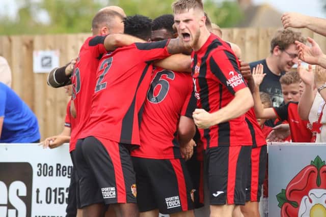 Dan Nti is mobbed by his Kettering Town team-mates after he scored the late winner to give them a 2-1 success over AFC Telford United on the opening day of the season. Pictures by Peter Short
