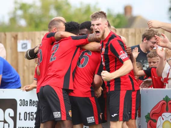 Dan Nti is mobbed by his Kettering Town team-mates after he scored the late winner to give them a 2-1 success over AFC Telford United on the opening day of the season. Pictures by Peter Short
