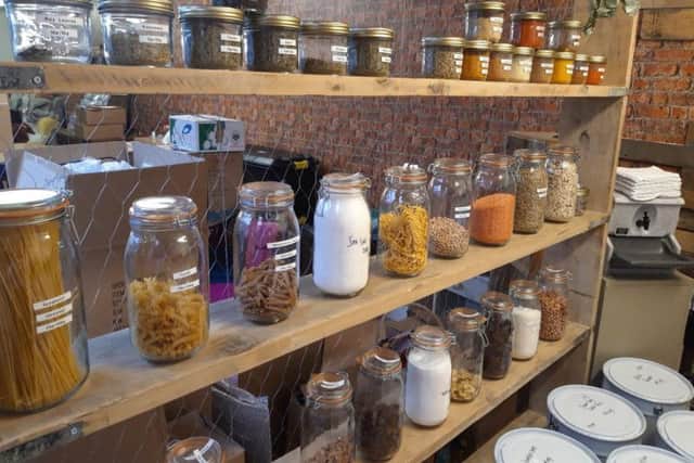 Loose spices and dried goods are sold by weight and dispensed into customers' own plastic tubs.