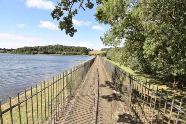 The reservoir is accessed via a path along the dam