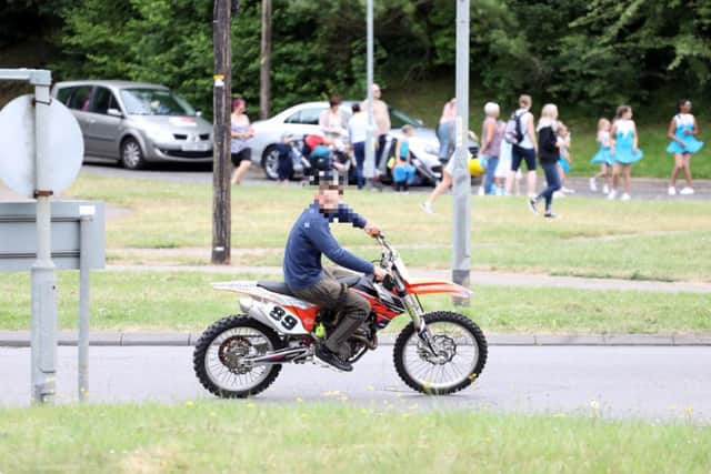 A rider without a helmet travels on Oakley Road during this year's Corby Carnival