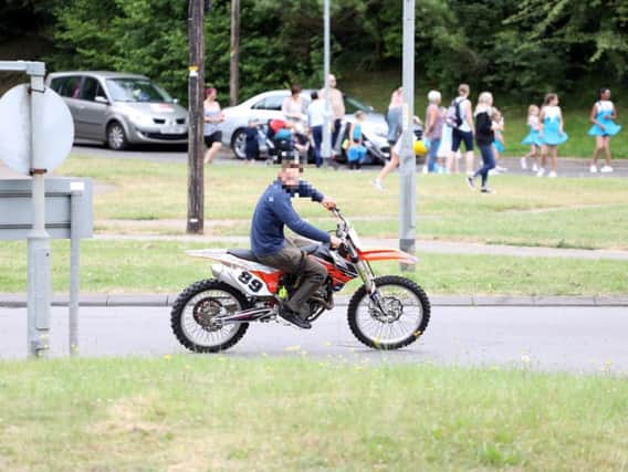 A rider without a helmet travels on Oakley Road during this year's Corby Carnival