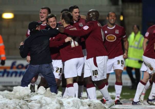 PILE ON! - Cobblers players and supporters celebrate after Roy O'Donovan's late winner against Torquay (Picture: Kelly Cooper)