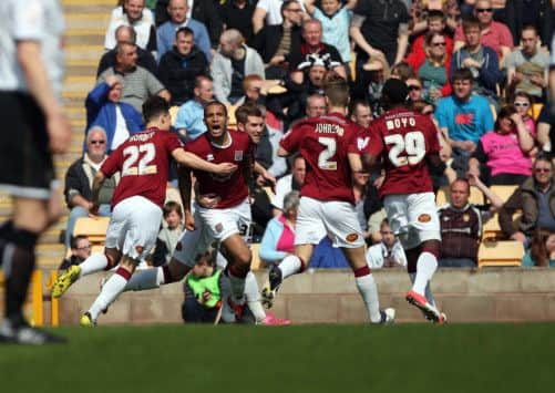 OFF TO A FLYER - Cobblers celebrate Clarke Carlisle's early goal at Vale Park (pictures: Kelly Cooper)