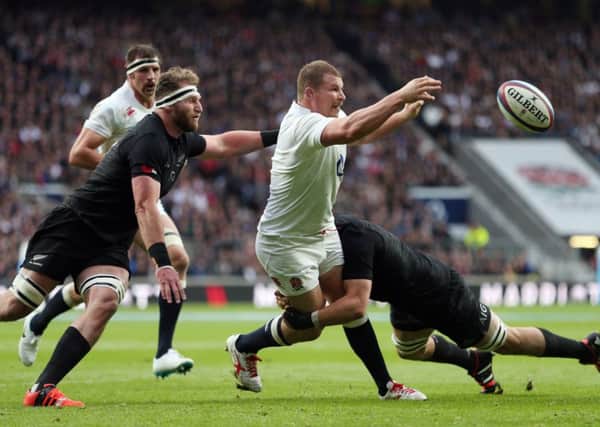Dylan Hartley is tackled by New Zealand's Richie McCaw and Kieran Read at Twickenham on Saturday