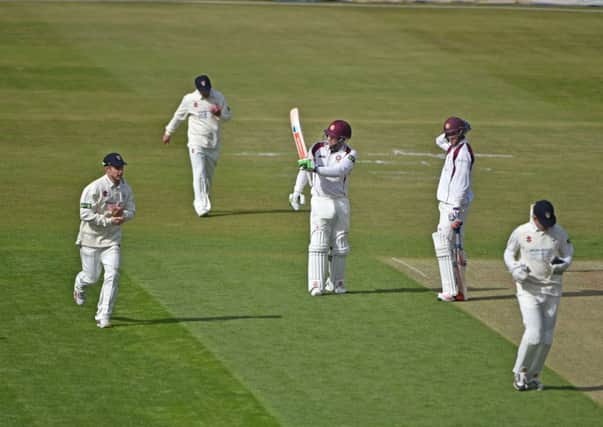 Adam Rossington raises his bat after reaching a half-century for Northamptonshire on the first day of the new LV County Championship Division Two season against Gloucestershire at the County Ground. Pictures by Dave Ikin