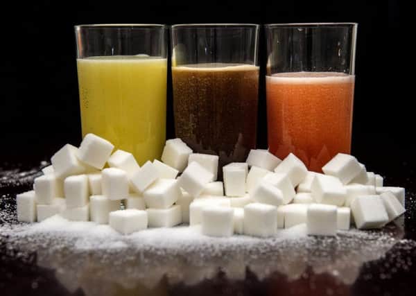 Carbonated drinks surrounded by sugar cubes, as Dr Alison Tedstone, director of diet and obesity for Public Health England (PHE), said that an official review has found a sugar tax could be effective at curbing childhood obesity.