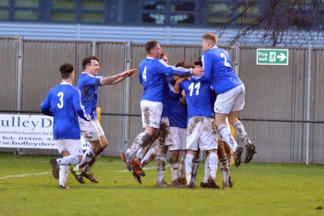 Andy White is mobbed by his Rothwell Corinthians team-mates after scoring his and his team's second goal in last weekend's superb 2-1 win at Holbeach United. Picture by Tim Wilson