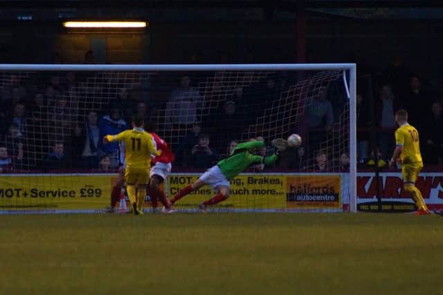 The Poppies' makeshift goalkeeper Brett Solkhon dives to his left to make a save