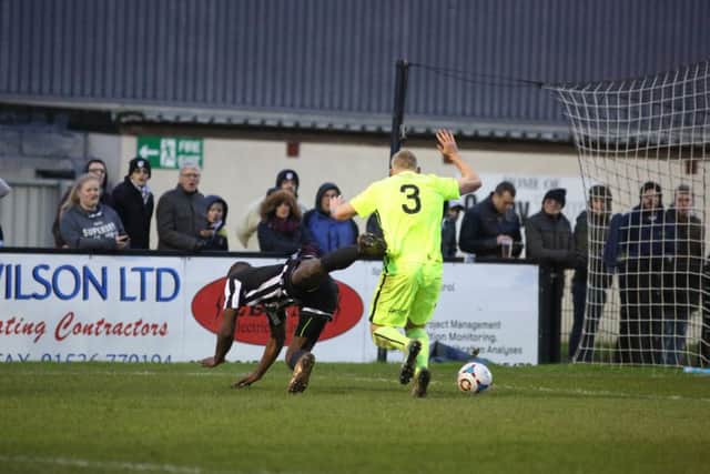 Ryan Robbins is fouled by Josh Lacey to earn Corby their penalty