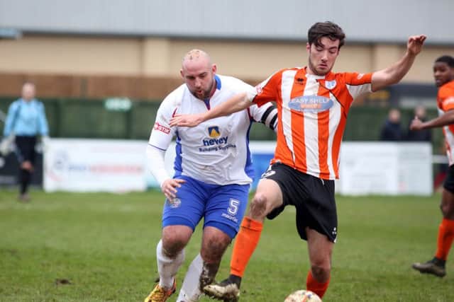 AFC Rushden & Diamonds captain Liam Dolman challenges Ware striker Harley Haag