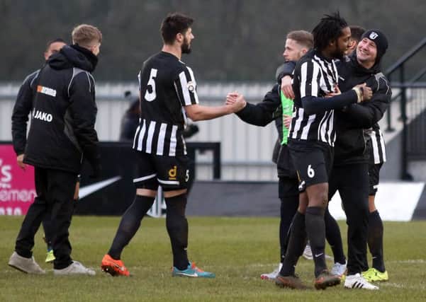 Corby Town's players and management celebrate at the final whistle as they beat Tamworth 2-0 at Steel Park. Pictures by Alison Bagley