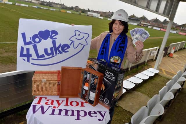 Kirsty Ward, chair of the fundraising committee at Burton Park Wanderers, alongside prizes donated to the Love4Luke fundraiser by Taylor Wimpey and other local companies.