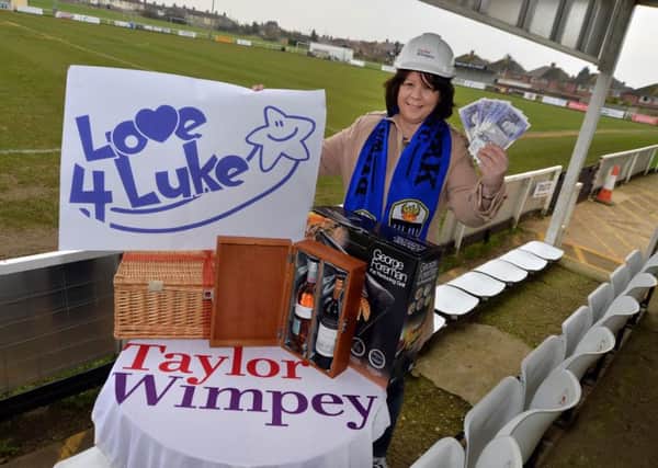 Kirsty Ward, chair of the fundraising committee at Burton Park Wanderers, alongside prizes donated to the Love4Luke fundraiser by Taylor Wimpey and other local companies.