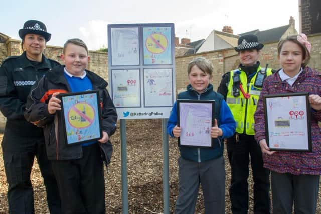 Three of the winning designers by the new sign on the corner of Mill Road and Linden Avenue in Kettering