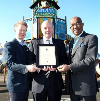 Dr Ahmed Mukhtar presents Wicksteed Park chairman Oliver Wicksteed and managing director Alasdair McNee with the award for the park's work in children's play
