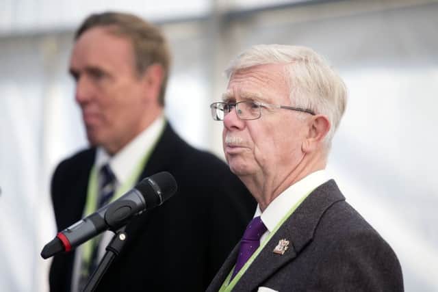 Councillor Jim Harker says he is willing to launch talks about splitting Northamptonshire's eight councils into a smaller number of unitary authorities.