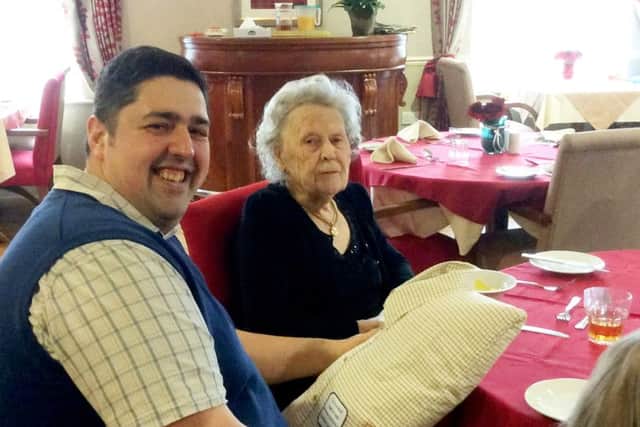Chris Rayatt-Howard hands Joyce Beckett the cushion made from her late husband's shirt. Picture: SWNS