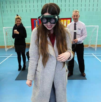 Student Polly MacDonald tries to walk a straight line wearing the 'drink-drive' goggles