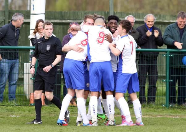 Jack Bowen is mobbed by his AFC Rushden & Diamonds team-mates after scoring their second goal in the 2-0 victory over Godalming Town. Pictures by Alison Bagley