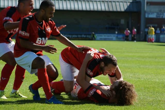 Liam Canavan is mobbed by his Kettering Town team-mates after he opened the scoring in their 2-0 win at Dorchester Town. Picture by Peter Short
