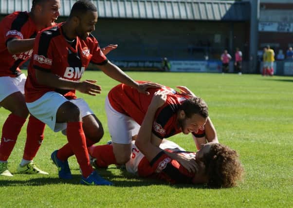 Liam Canavan is mobbed by his Kettering Town team-mates after he opened the scoring in their 2-0 win at Dorchester Town. Picture by Peter Short