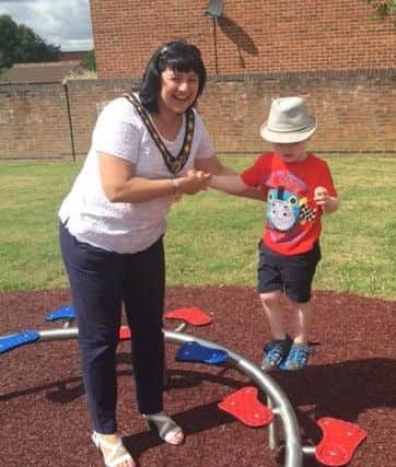 Raunds mayor Cllr Helen Howell helping a youngster on the equipment at the Webb Road play area