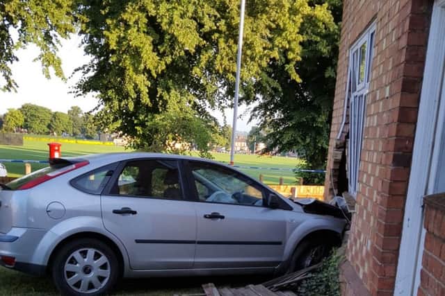 The Ford Focus remains lodged in the sitting room of a home in Queen Eleanor Road this morning. A joyrider crashed the vehicle into the home around 1am.