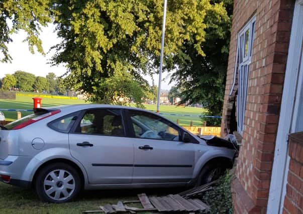The Ford Focus remains lodged in the sitting room of a home in Queen Eleanor Road this morning. A joyrider crashed the vehicle into the home around 1am.