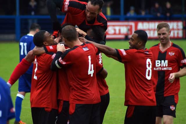 Nathan Hicks is mobbed by his Kettering Town team-mates after scoring their second goal at Leek
