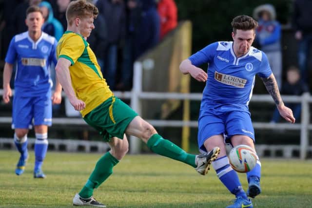 Ben Ford, pictured in blue playing for Biggleswade Town, has signed for AFC Rushden & Diamonds