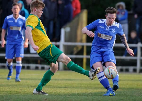 Ben Ford, pictured in blue playing for Biggleswade Town, has signed for AFC Rushden & Diamonds