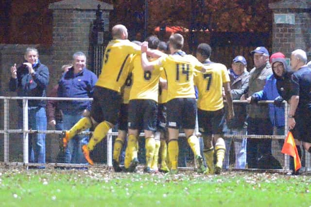 Richard Bunting is mobbed by his AFC Rushden & Diamonds team-mates after scoring their equaliser in last night's fine 2-1 success at Spalding United. Pictures by Tim Wilson