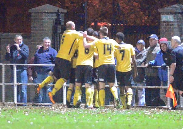Richard Bunting is mobbed by his AFC Rushden & Diamonds team-mates after scoring their equaliser in last night's fine 2-1 success at Spalding United. Pictures by Tim Wilson