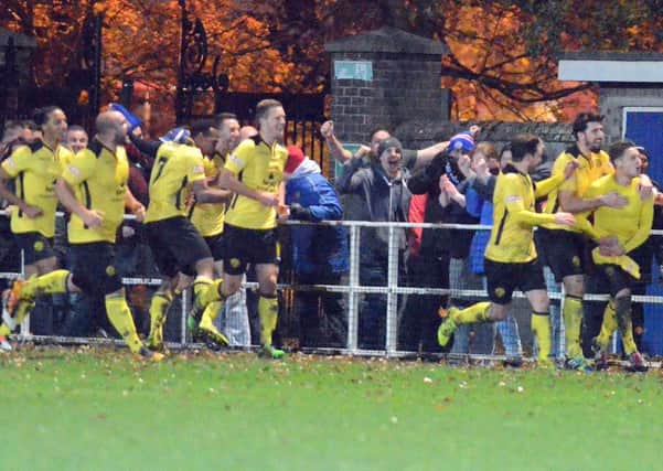 AFC Rushden & Diamonds' players and fans celebrate Jack Ashton's winner at Spalding United on Tuesday night. Picture by Tim Wilson