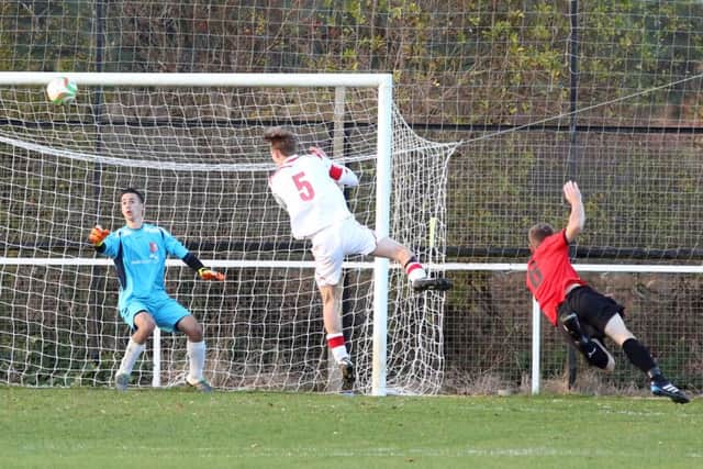 Nathan Heycock scores Irchester United's fifth goal in their 7-0 thrashing of Woodford United last weekend. Pictures by Alison Bagley