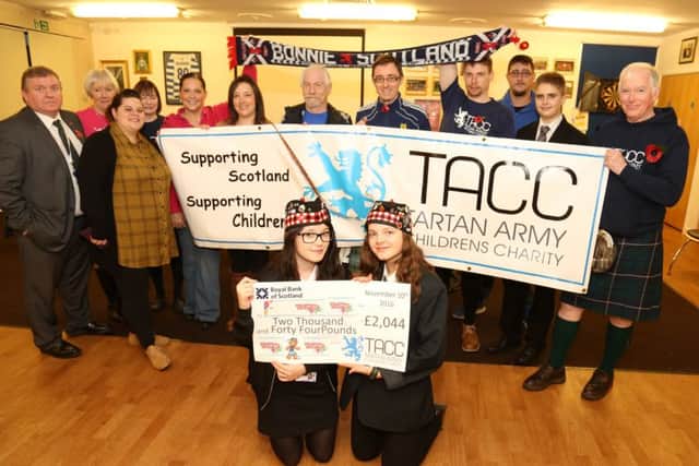 Tartan Cash: Corby: Youthie receive cheque at West Glebe Pavilion from the Tartan Army Childrens Charity for an extra storage container. Front row: Riki Judkins, 17, and Ashleigh Maynard, 15, with Youthie members and the Tartan Army Childrens Charity