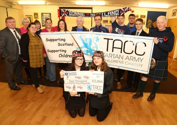 Tartan Cash: Corby:  Youthie receive cheque at West Glebe Pavilion from the Tartan Army Childrens Charity for an extra storage container. Front row: Riki Judkins, 17, and Ashleigh Maynard, 15, with  Youthie members and the Tartan Army Childrens Charity