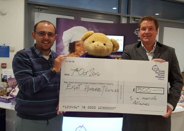 Stuart Marriott (L) and Ash Davies (R) hand over their cheque to Great Ormond Street Hospital.