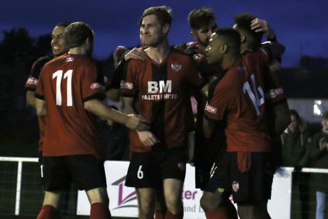 Rene Howe is mobbed by his Kettering Town team-mates after scoring their winner against Dorchester Town. Pictures by Peter Short